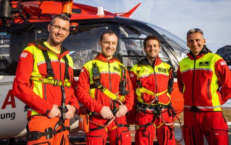 Vier Personen, die Crew des Rettungshubschrauber RK-2, steht vor einem Hubschrauber.